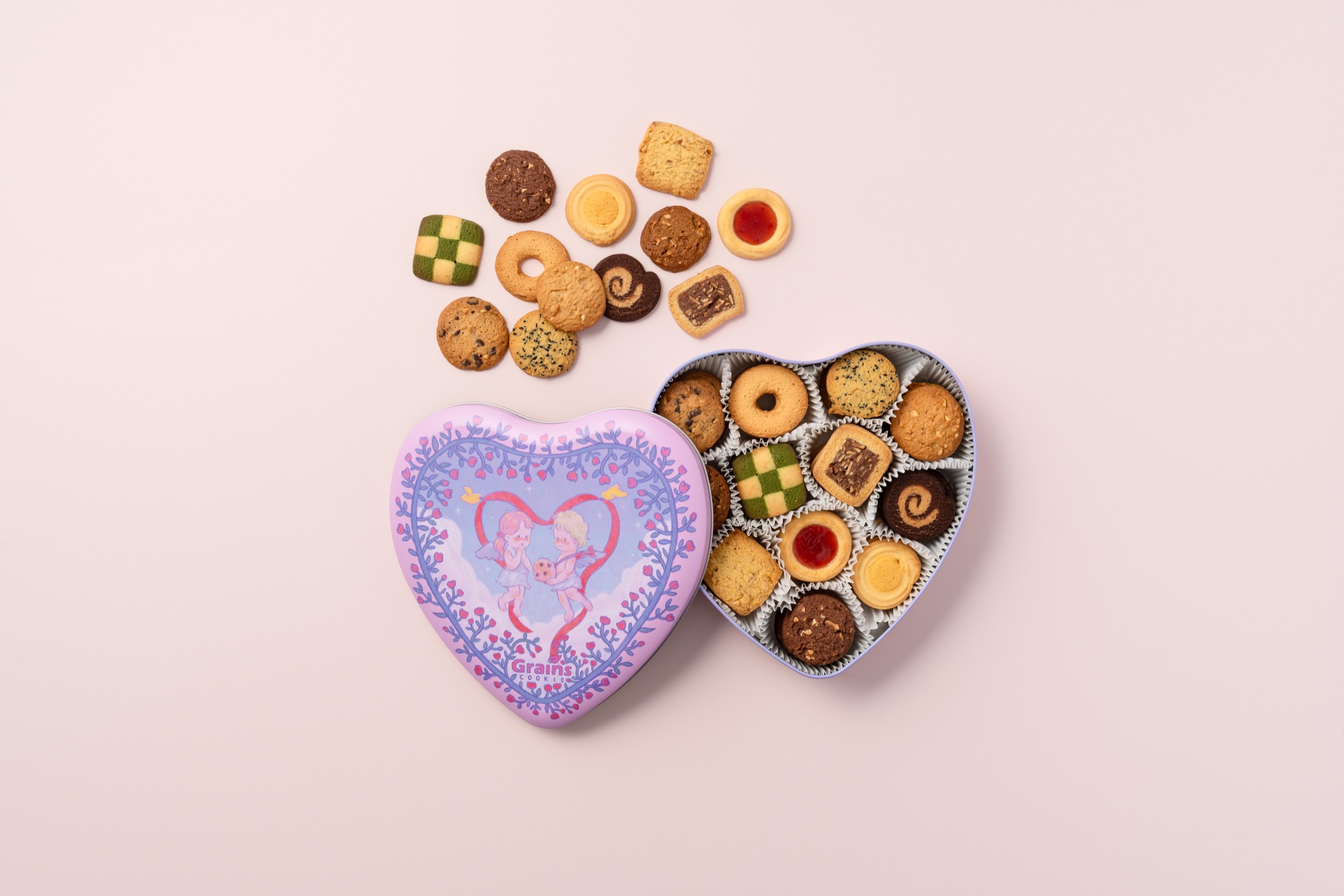 Open and closed illustrated heart-shaped cookie tin packaging.
